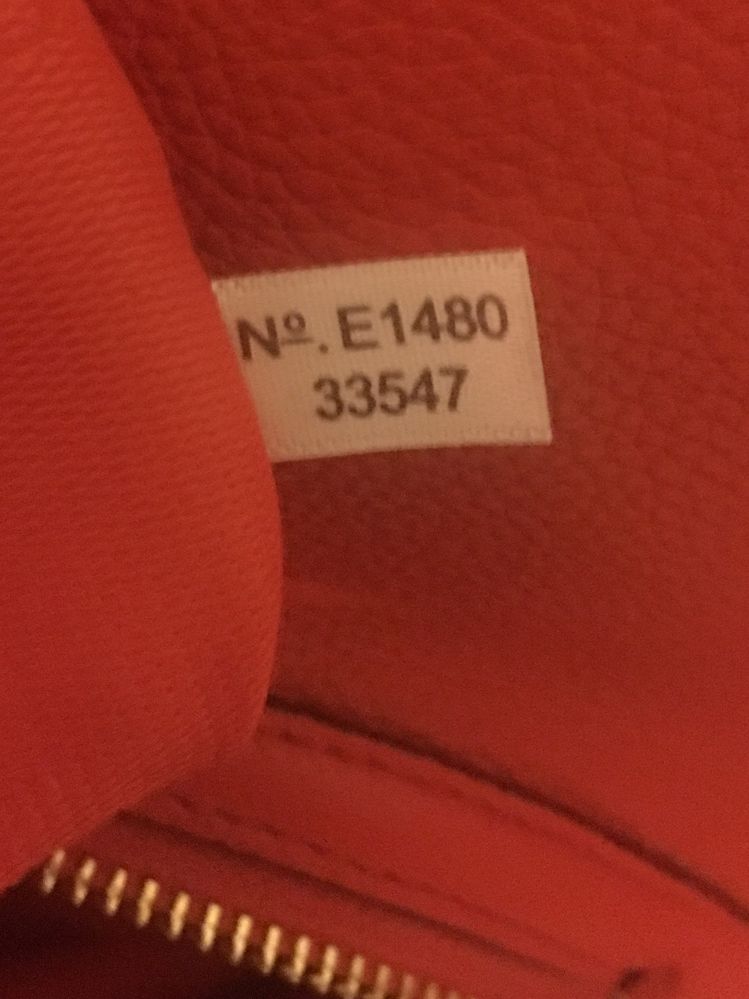 serial number is on white fabric tag inside of zipper pocket.